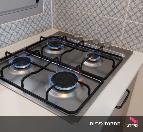 כיריים גז עם ארבעה מבערים דולקים